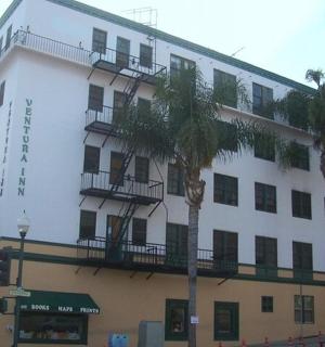 a large white building with palm trees in front of it