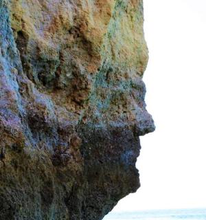 a close up of a rock wall next to the ocean