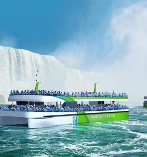 a group of people on a boat in front of a waterfall