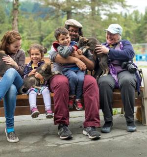 一群人和狗坐在长椅上