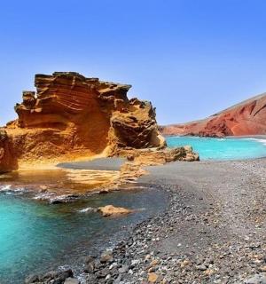 a beach with rocks and water and a cliff