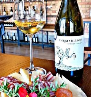 ένα μπουκάλι λευκό κρασί δίπλα σε ένα ποτήρι κρασιού