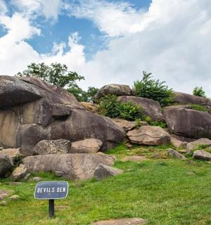 a sign in front of a pile of rocks