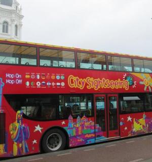 ein roter Doppeldeckerbus fährt eine Straße entlang