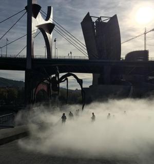 skupina lidí kráčejících v páře před mostem