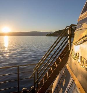 a boat on the water with the sun setting