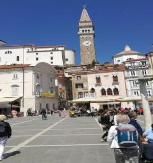 一群人沿着有钟楼的街道行走