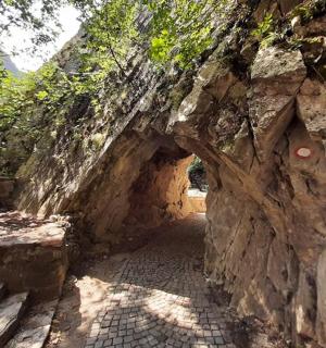 an entrance to a stone wall with a stone tunnel
