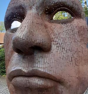 栅栏前的男人脸雕像