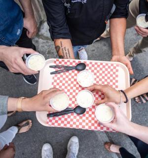 skupina lidí stojících kolem stolu s nápoji