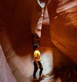 a man is standing in a slot canyon
