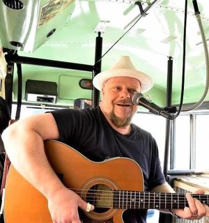 a man playing a guitar in a bus