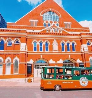 一辆橙色的双层巴士停在一栋建筑物前