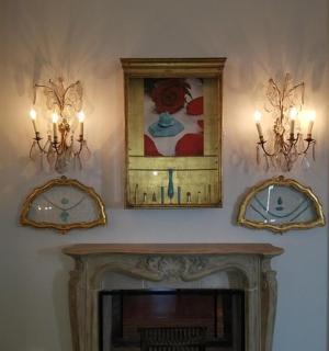 a living room with three chandeliers and a fireplace