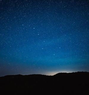 hvězdná noc se siluetou hory