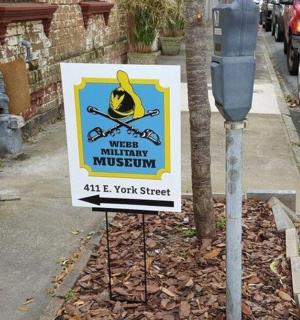 a sign on a street next to a parking meter