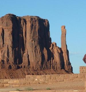 一名男子站在岩层旁的墙上