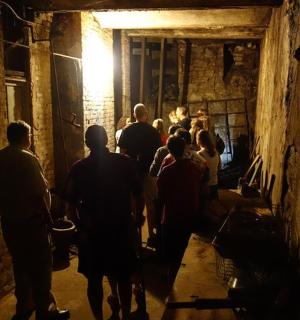 skupina lidí kráčejících temným tunelem