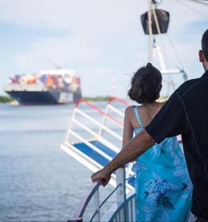muž a žena stojící na lodi a dívající se na loď