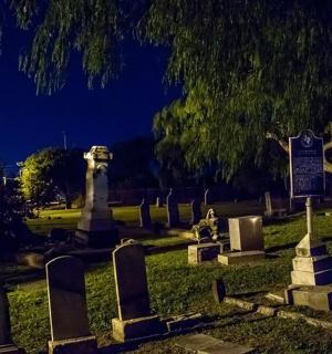 a group of gravestones in a cemetery at night