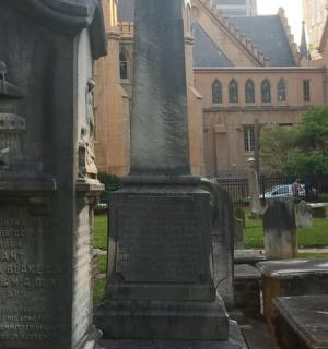 a monument in a cemetery in front of a building