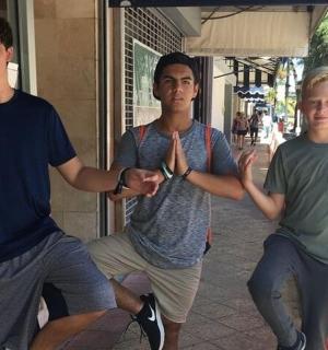 tři mladí muži dávají znamení míru