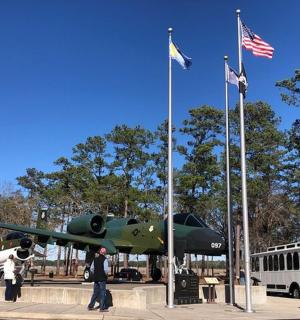 letadlo vystavené vedle autobusu a vlajek