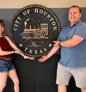 a man and a woman standing in front of a sign
