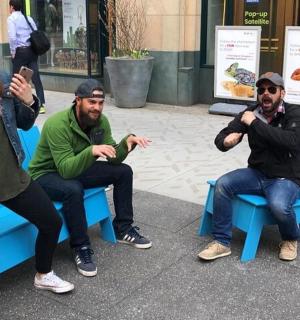 三个人坐在蓝色长椅上