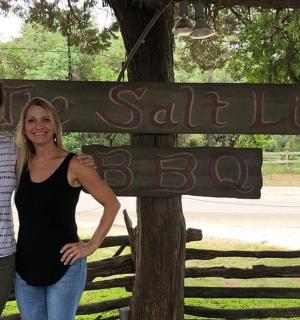 two women standing in front of a street sign