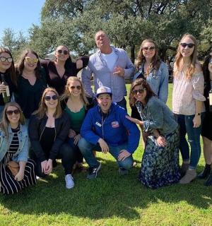 skupina lidí pózujících pro fotografii v trávě