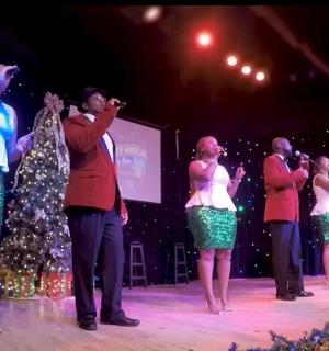 a group of people singing on a stage