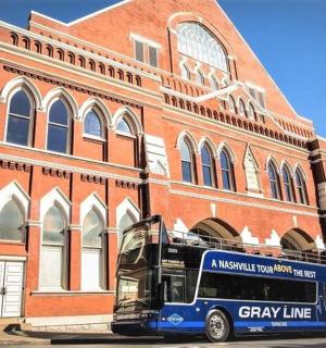 一辆蓝色巴士停在一栋砖砌建筑前