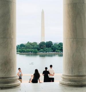 Skupina lidí stojících před Washingtonským monumentem