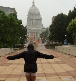 a person walking down a street with their arms outstretched