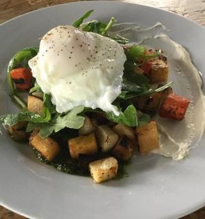 bílý talíř se salátem a vejcem na něm