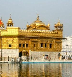 a golden temple with water in front of it