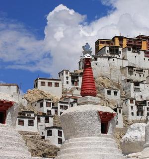 a group of stone structures with a building in the background