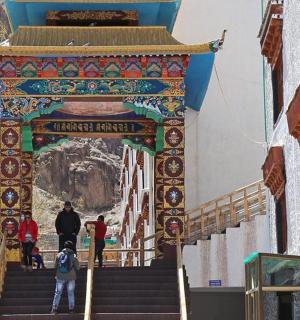 a gate to a temple with people walking up the stairs