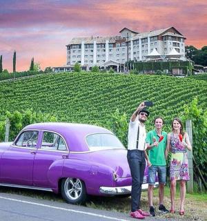 a group of people standing next to a purple car