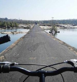 a bike is parked on a road next to water