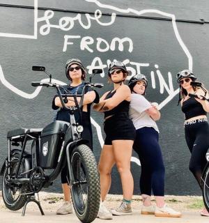 skupina žen stojící vedle motorky