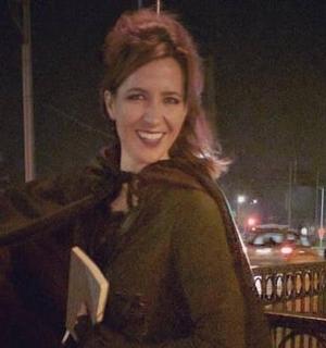 一位女士手里拿着一本书,面带微笑