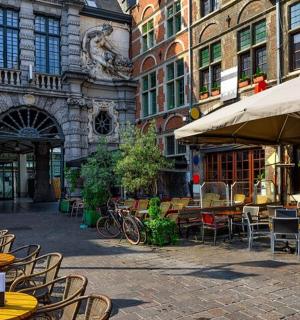 a patio with tables and chairs in front of a building