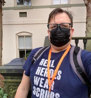 a man wearing a mask in front of a building