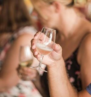 maður heldur á glasi af hvítvíni