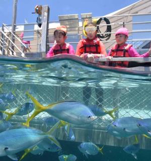 two people on a boat in the water with fish