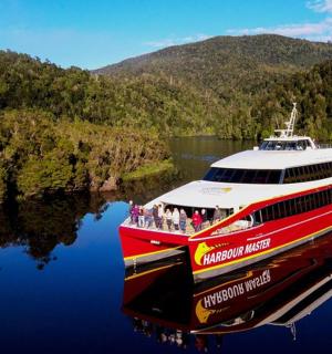 a red and white boat floating on a lake