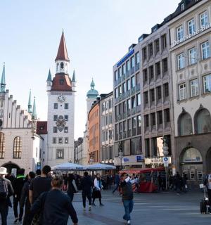 a group of people walking in a city with buildings