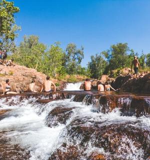 a group of people sitting on top of a waterfall